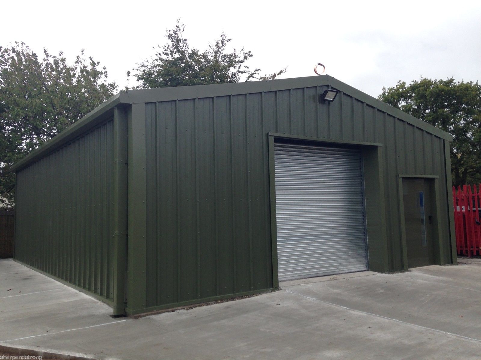 Large steel building with a roller shutter and personnel access door